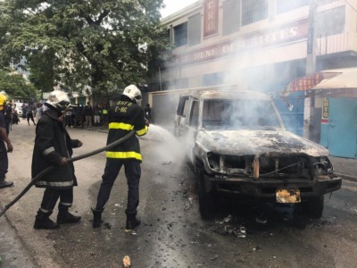 Deux voitures de la PNH en feu à l'Avenue Christophe, des manifestants foulent le macadam 1